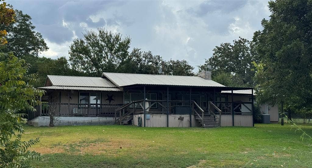 10122 Ash Cove, Wills Point, TX 75169 Corrugated metal roofing, expansive covered porch, wood exterior siding, and brick chimney