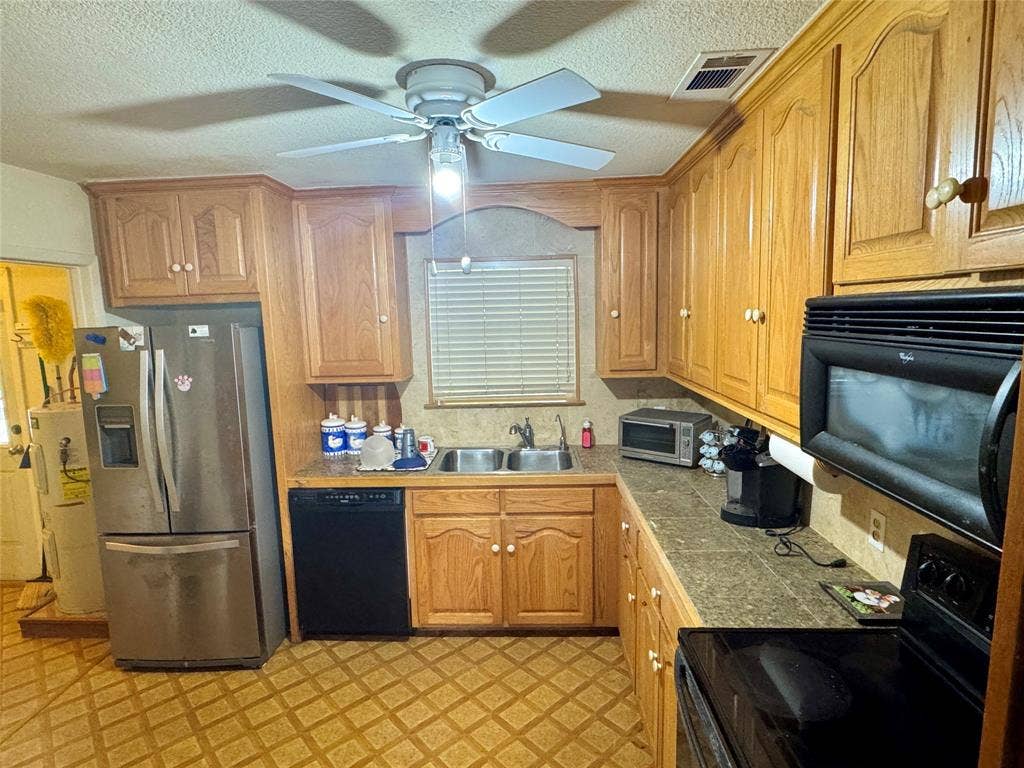 10122 Ash Cove, Wills Point, TX 75169 Kitchen featuring wood cabinetry, laminate countertops, a double basin sink, and a ceiling fan