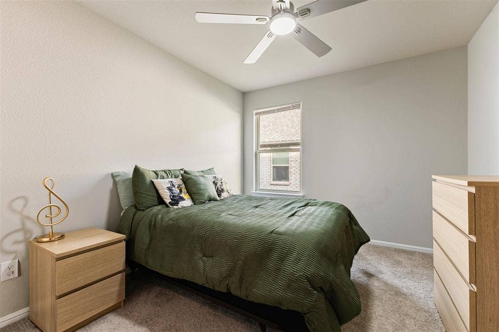Bedroom featuring light colored carpet and ceiling fan