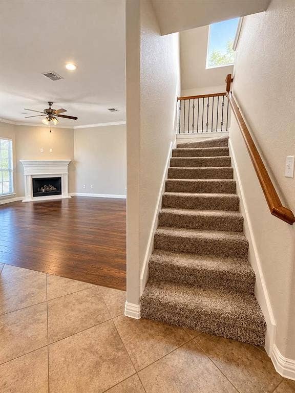 Carpeted staircase with wrought iron balusters and a wood-finish handrail