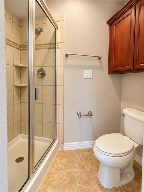 Glass-enclosed shower with tiled walls and built-in shelving