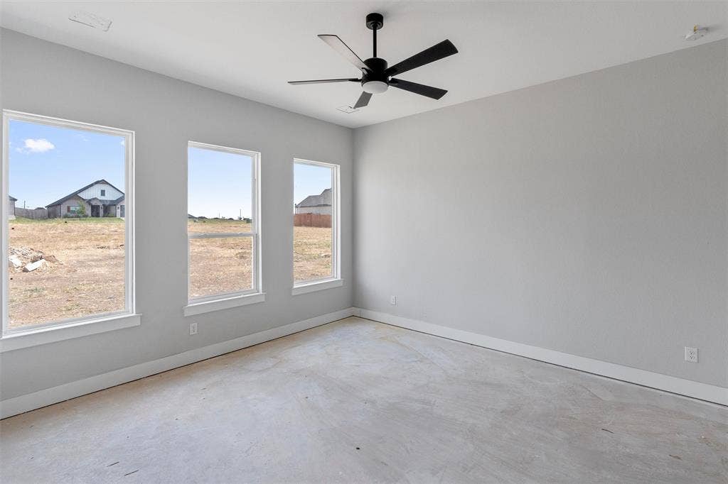 1312 Tahonta Drive, Hewitt, TX 76643 Three large windows with white trim, a matte black ceiling fan, and light gray walls