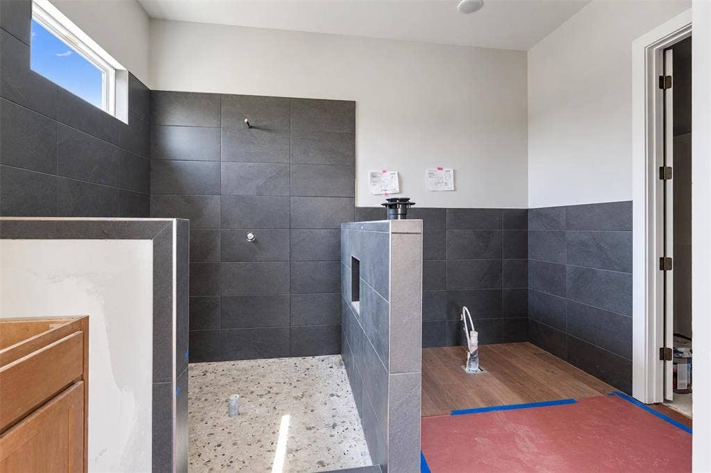 1312 Tahonta Drive, Hewitt, TX 76643 Walk-in shower with dark tile surround and a terrazzo-style floor