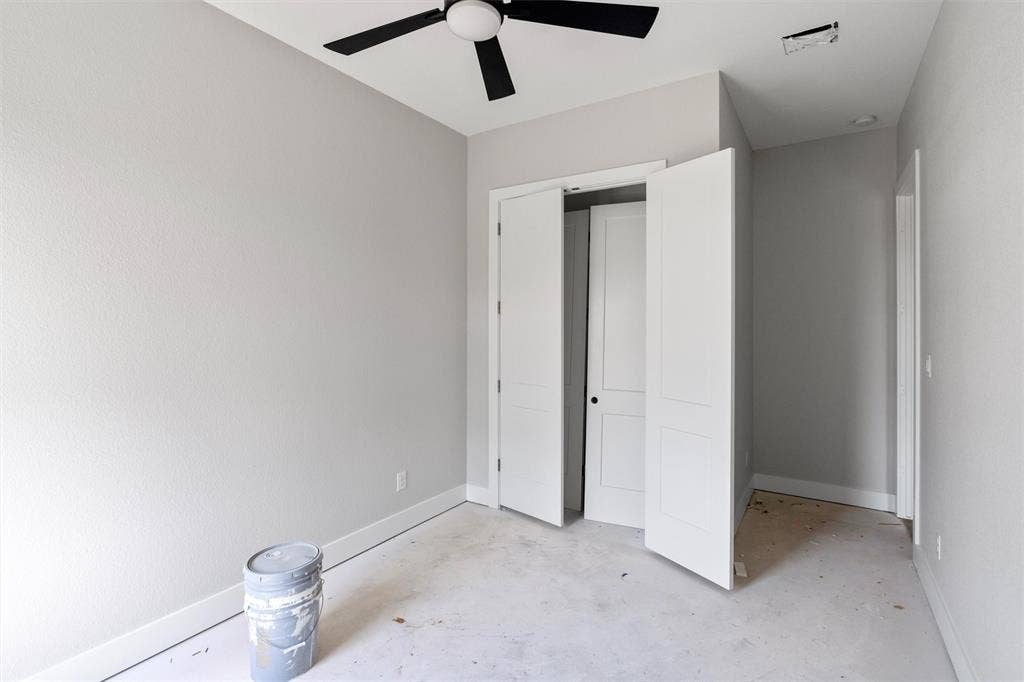 1312 Tahonta Drive, Hewitt, TX 76643 Modern ceiling fan with black blades, bi-fold closet doors, and light gray wall paint