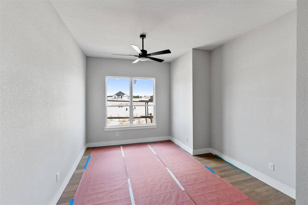 1312 Tahonta Drive, Hewitt, TX 76643 Recessed window with white trim, wood-finish flooring, ceiling-mounted fan with black blades, white painted walls, and white ceiling