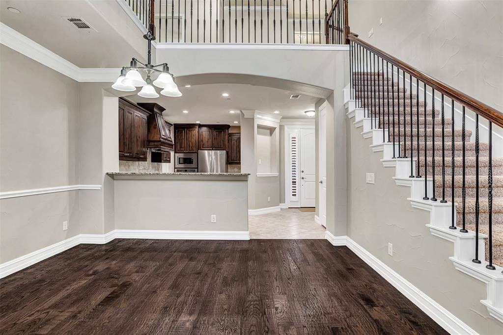 4817 BAYVIEW Drive, Plano, TX 75093 A staircase with wrought iron balusters leads to the game room and secondary bedrooms above, while keeping the home open, airy and bright! You can see how the floor plan flows from the front door to the kitchen, dining area and living room.
