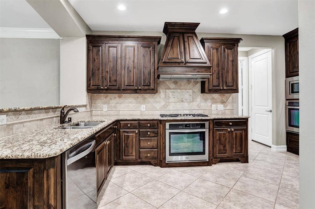 4817 BAYVIEW Drive, Plano, TX 75093 Just inside the foyer you'll get your first glimpse of this magnificent gourmet kitchen! It features a gas cooktop, vent, warm wood cabinets and double ovens!