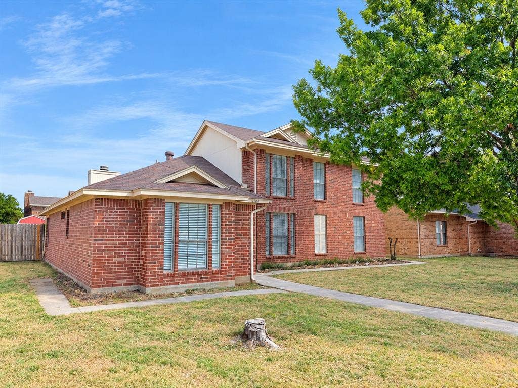 7801 Cornell Drive, Rowlett, TX 75088 Brick exterior with light-colored gables, multiple windows, and a concrete walkway