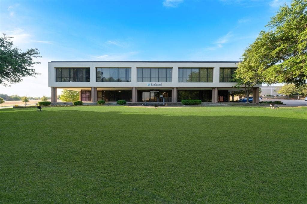 1701 W Walnut Hill Lane, #100, Irving, TX 75038 Two-story commercial building featuring extensive landscaping, columned entrance, and large windows
