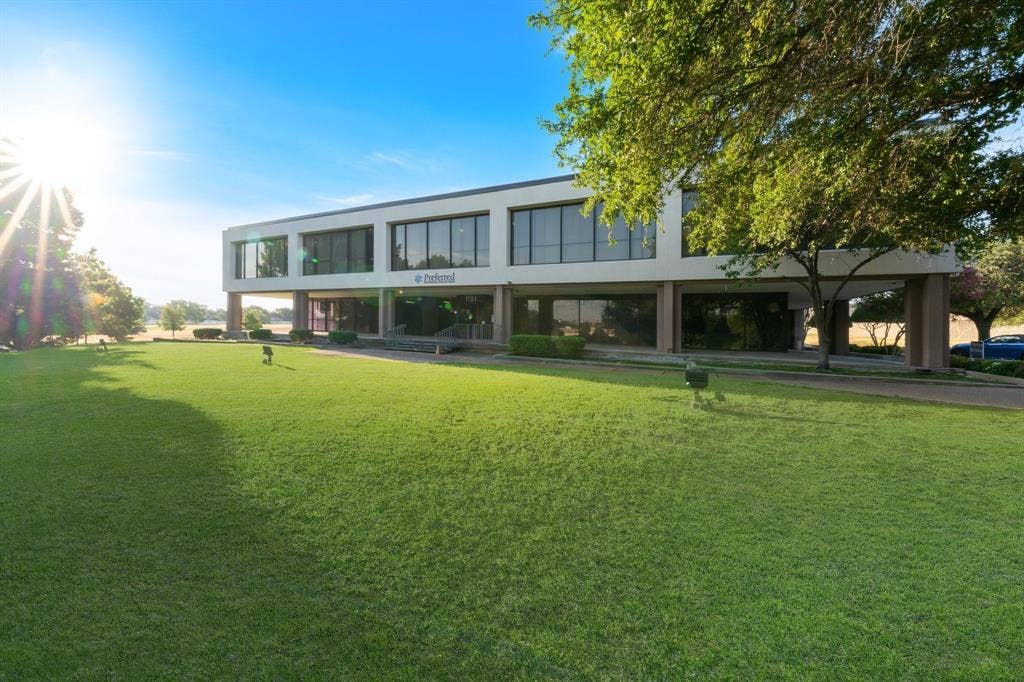 1701 W Walnut Hill Lane, #100, Irving, TX 75038 Modern architecture building with a landscaped lawn, expansive windows, and a portico entrance