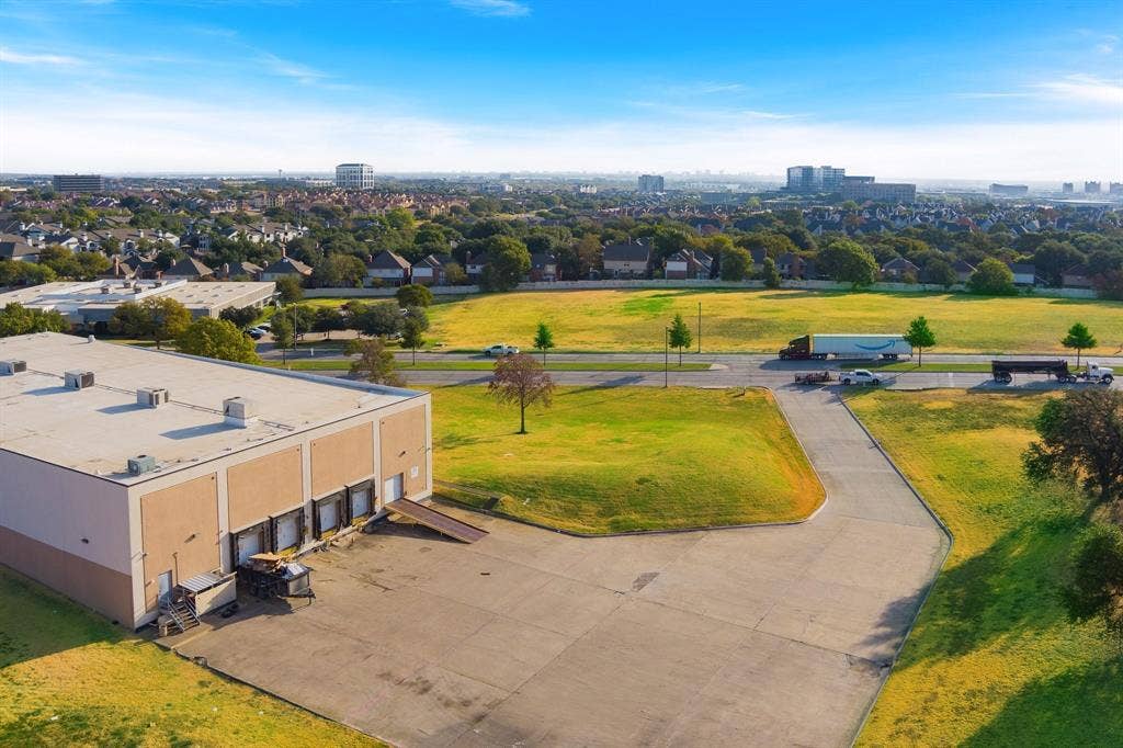 1701 W Walnut Hill Lane, #100, Irving, TX 75038 Industrial building featuring multiple loading docks, a concrete parking area, and a flat roof