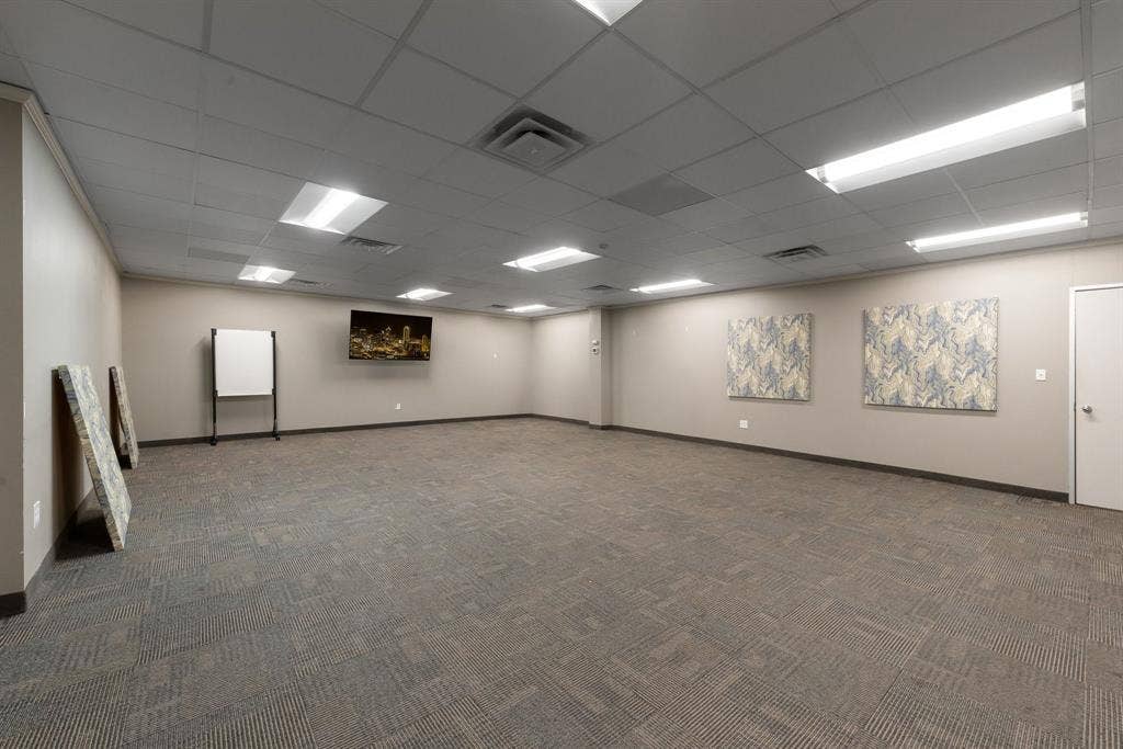 1701 W Walnut Hill Lane, #100, Irving, TX 75038 Recessed ceiling panels, ample overhead lighting, neutral wall tones, and patterned carpet flooring, conference room or training space.