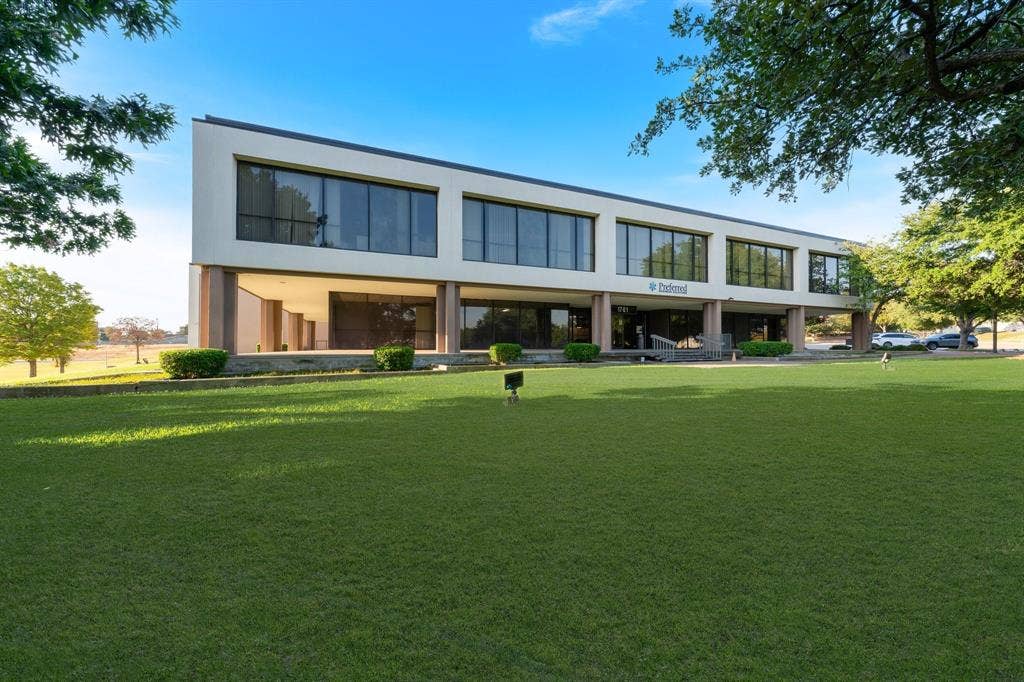 1701 W Walnut Hill Lane, #100, Irving, TX 75038 Two-story commercial building featuring extensive glazing, a prominent entry, and a manicured lawn