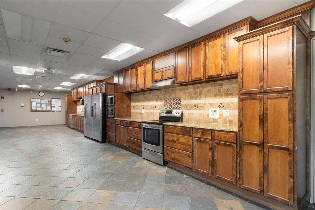 1701 W Walnut Hill Lane, #100, Irving, TX 75038 Extensive wood-finish cabinetry, granite-style countertops, and a full tile backsplash