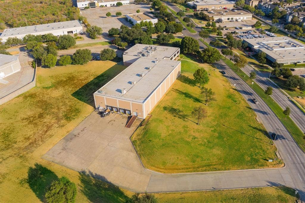 1701 W Walnut Hill Lane, #100, Irving, TX 75038 Commercial building with multiple loading docks, an expansive paved lot, and a large grassy area