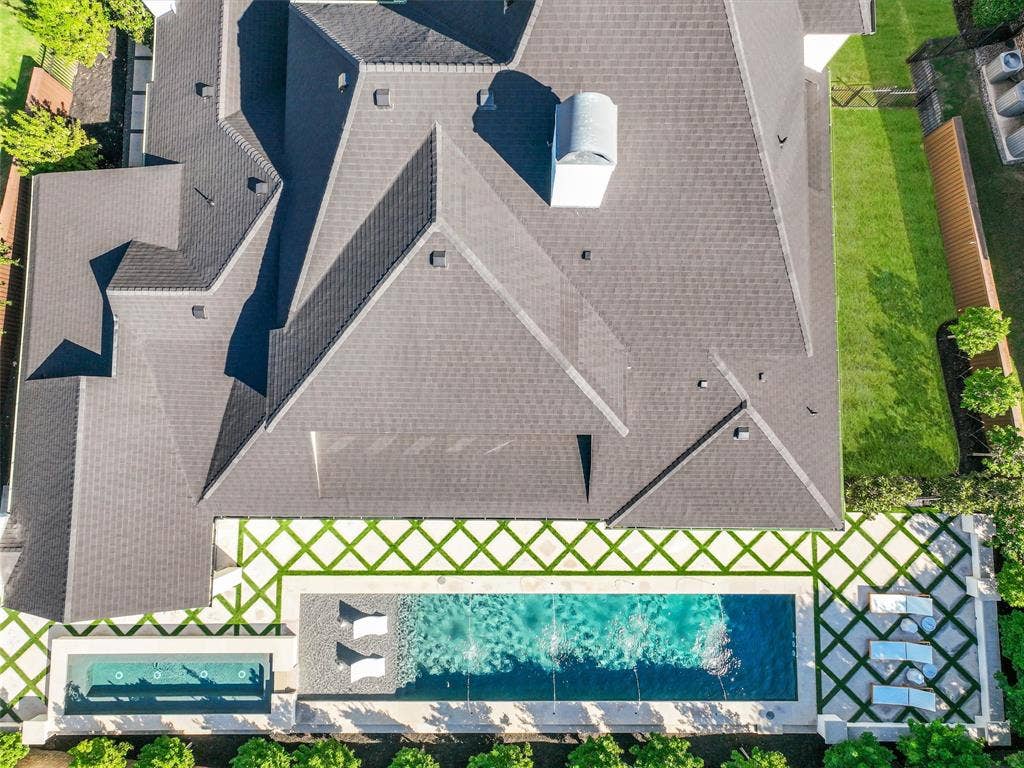 12313 Winding Hollow Lane, Frisco, TX 75033 SIDE YARD GRASS. While the interior is impressive, the outdoor living environment elevates this Newman Village home to another level. Designed as a private resort, the backyard centers around a custom heated pool completed in 2023. The pool is equipped with two Speck X commercial-grade swim jets, allowing for an enhanced swimming experience without leaving home. Eight deck jets add movement and visual interest, while the tanning ledge creates a relaxing space for enjoying warm Texas afternoons. Polaris equipment completes the thoughtfully designed pool system.The pool area also includes three chaise lounges, two side tables, two umbrella stands, and two Ledge Lounger chairs, creating multiple spaces for relaxing poolside. Whether enjoying a quiet afternoon in the sun or entertaining friends and family, the backyard was designed to accommodate both intimate gatherings and larger celebrations. Attached to the pool is an impressive custom spa completed in 2023.
