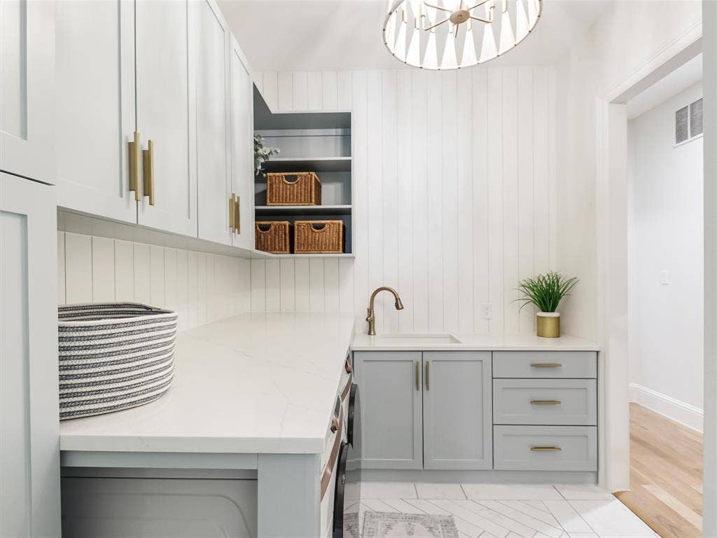 12313 Winding Hollow Lane, Frisco, TX 75033 . Direct access from the primary suite area to the laundry room adds an exceptionally practical feature to the floor plan. The beautifully finished laundry room includes Pilar quartz countertops, a Bianco Liven sink, Delta faucet, extensive custom cabinetry, and Samsung front-load washer and dryer installed in 2023.
