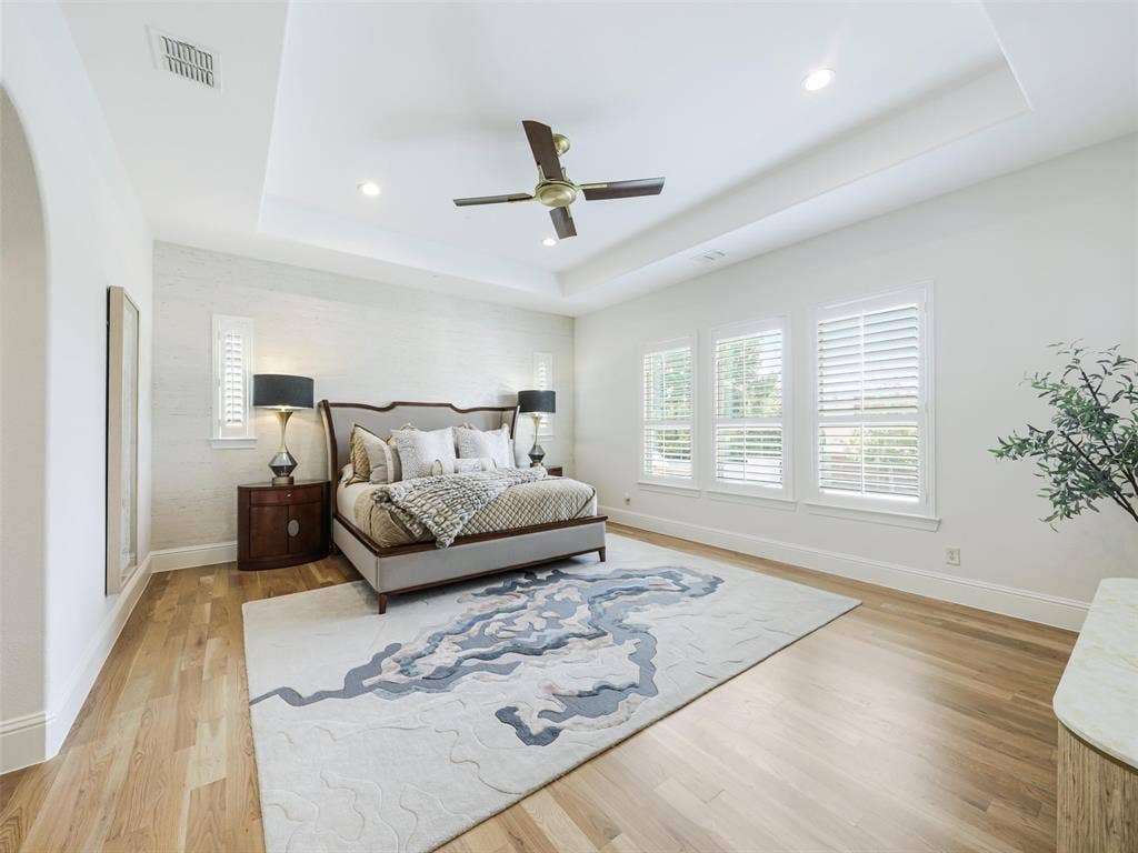 12313 Winding Hollow Lane, Frisco, TX 75033 The primary suite offers a luxurious escape from the rest of the home. Custom white oak double doors introduce a beautifully designed retreat that continues into a spa-inspired ensuite bath. High-end finishes include Fumo marble countertops, oversized custom mirrors, a generous 72-by-36-inch soaking tub, Delta faucets, rain shower, body spray jets, and tub faucet. The combination of natural stone, designer fixtures, and generous proportions creates the feeling of a private luxury spa within the home.Storage is equally impressive with a spacious 12-by-11-foot primary walk-in closet. Direct access from the primary suite area to the laundry room adds an exceptionally practical feature to the floor plan.