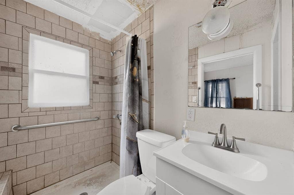 White vanity with integrated sink and brushed nickel faucet