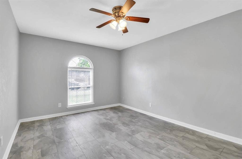 1509 California Trail, Grand Prairie, TX 75052 Spacious room featuring light gray walls, wood-finish flooring, and a ceiling fan with integrated lighting