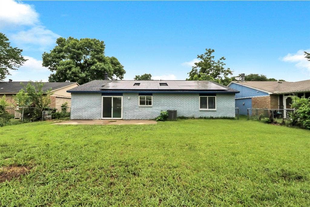 1509 California Trail, Grand Prairie, TX 75052 Expansive backyard featuring a patio, sliding glass door entry, and solar panels on the roof
