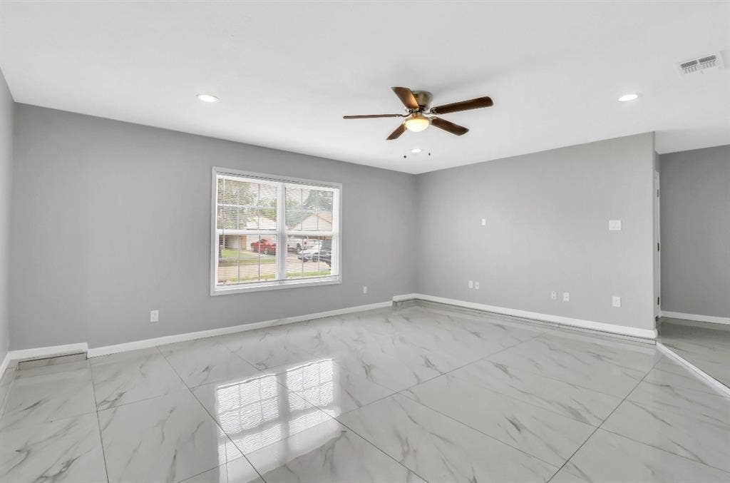 1509 California Trail, Grand Prairie, TX 75052 Spacious room featuring large format tile flooring, crisp white baseboards, and neutral gray walls