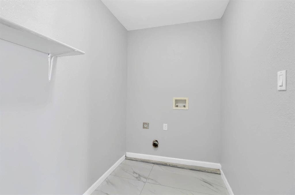 1509 California Trail, Grand Prairie, TX 75052 Dedicated utility space featuring light gray walls, a built-in white shelf, and light-toned tile flooring