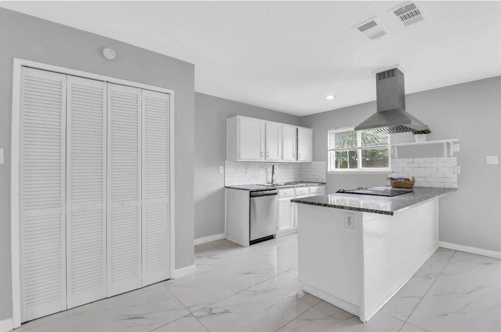 1509 California Trail, Grand Prairie, TX 75052 Kitchen featuring a central island with a built-in cooktop, stainless steel range hood, white cabinetry, and a subway tile backsplash