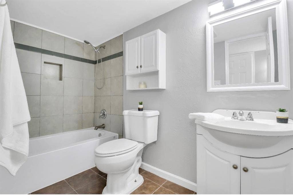 1509 California Trail, Grand Prairie, TX 75052 Full bathroom featuring a tub-shower combination with tiled surround, a recessed shower niche, and a wall-mounted shower head
