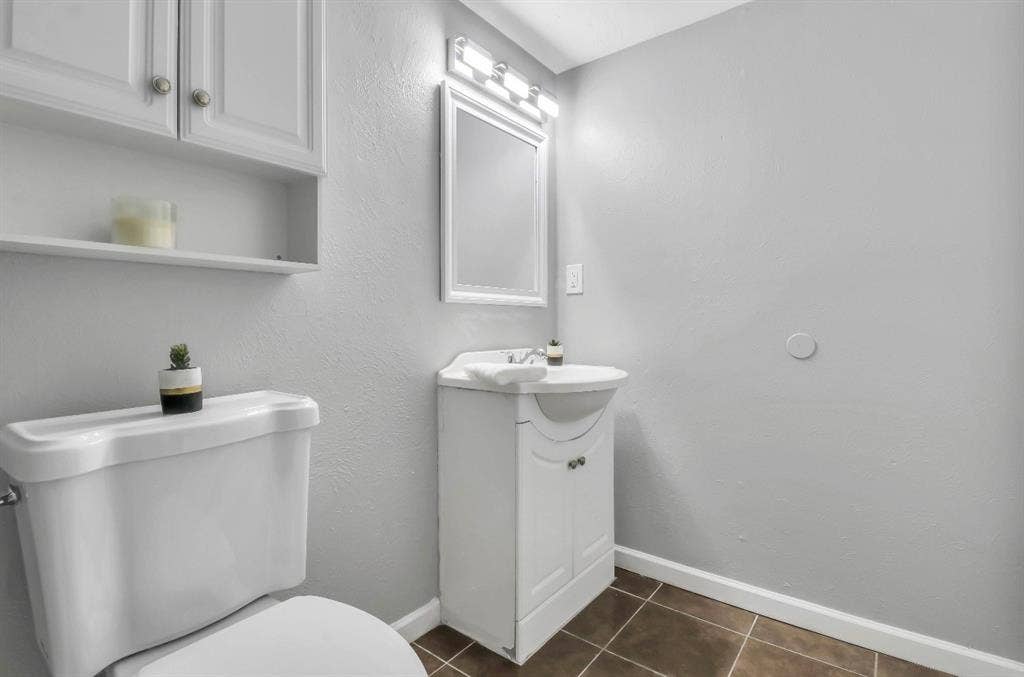 1509 California Trail, Grand Prairie, TX 75052 Bathroom featuring a white vanity with integrated sink, coordinating mirror, and overhead vanity lighting