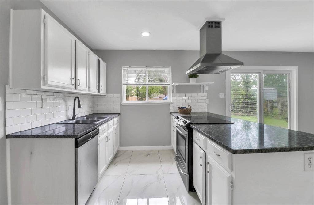 1509 California Trail, Grand Prairie, TX 75052 Modern kitchen featuring white cabinetry, dark stone countertops, subway tile backsplash, stainless steel appliances, and a sliding glass door