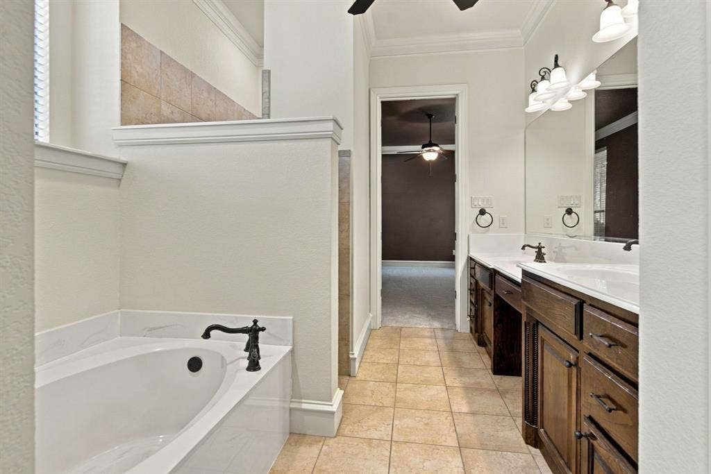 7004 Cherrybark Lane, North Richland Hills, TX 76182 Dual vanity with dark wood-finish cabinetry, integrated sinks, and bronze-finish fixtures