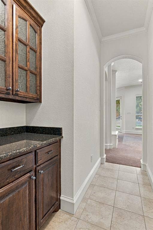7004 Cherrybark Lane, North Richland Hills, TX 76182 Built-in cabinetry with glass panel doors, dark countertop, and tile flooring