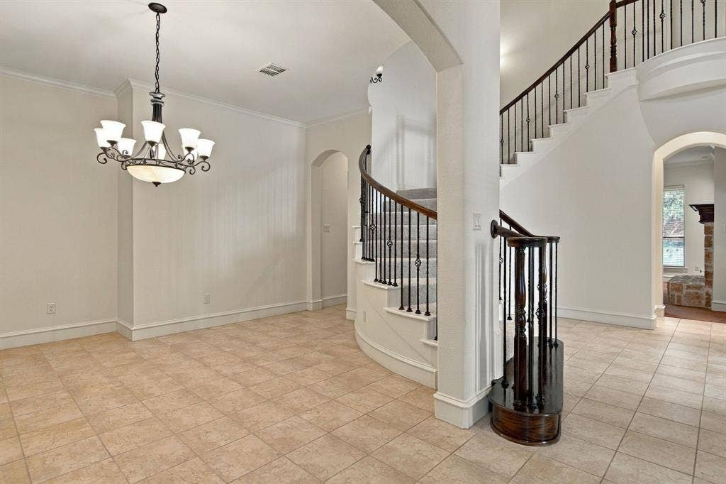 7004 Cherrybark Lane, North Richland Hills, TX 76182 Grand curved staircase with wrought iron balusters and wood handrail