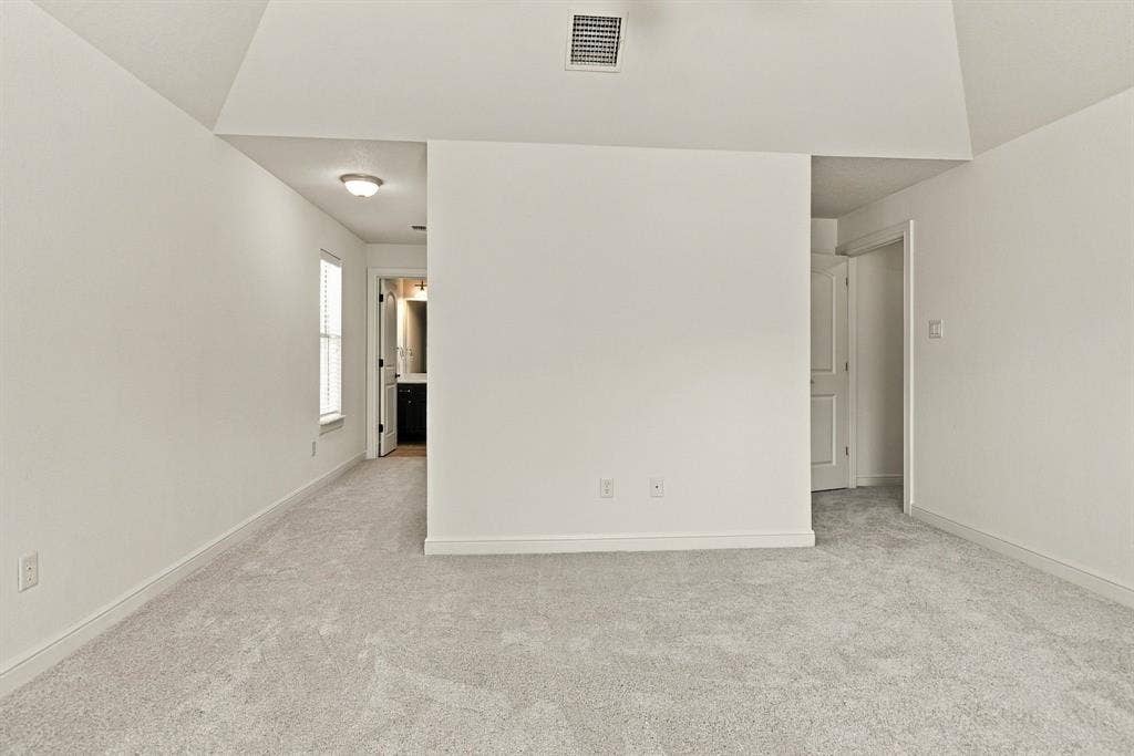 7004 Cherrybark Lane, North Richland Hills, TX 76182 Vaulted ceiling with an overhead vent, light-toned carpeted flooring, and a white interior door