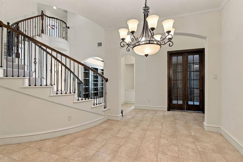 7004 Cherrybark Lane, North Richland Hills, TX 76182 Curved staircase with wrought iron balusters and wood handrail