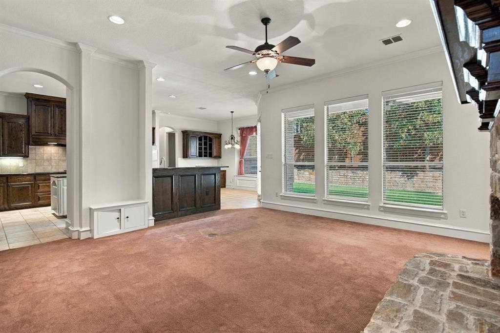 7004 Cherrybark Lane, North Richland Hills, TX 76182 Recessed lighting, ceiling fan with integrated lighting, built-in cabinetry, stone-clad fireplace, and multiple windows