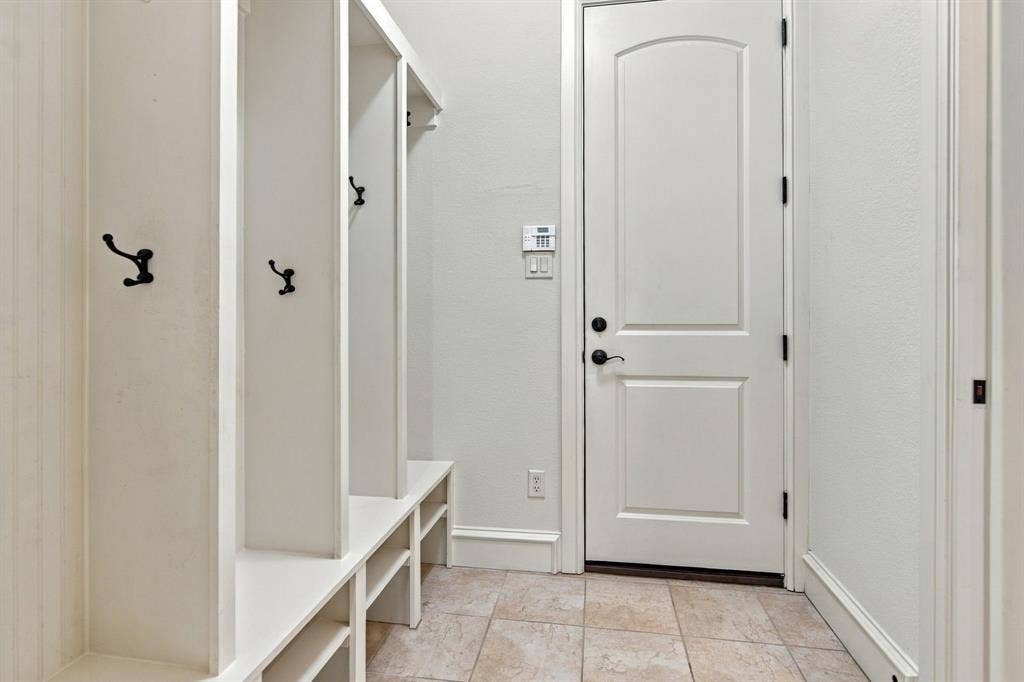 7004 Cherrybark Lane, North Richland Hills, TX 76182 Built-in white cubbies with black hooks, bench seating, and lower storage