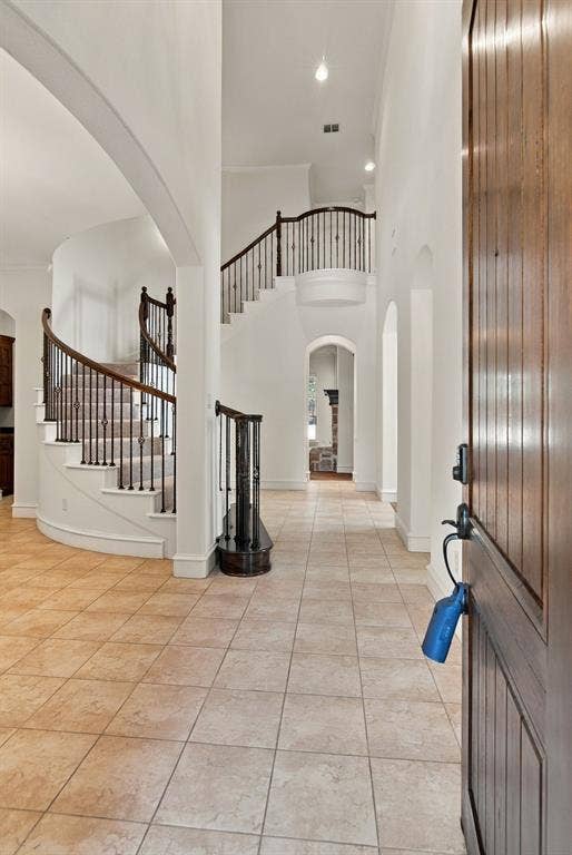 7004 Cherrybark Lane, North Richland Hills, TX 76182 Grand entry featuring a curved staircase with wrought iron balusters, high ceilings, recessed lighting, and tile flooring
