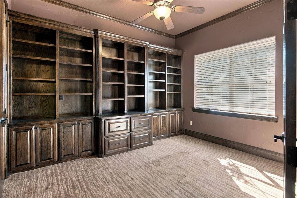 7004 Cherrybark Lane, North Richland Hills, TX 76182 Built-in wood cabinetry, integrated shelving, and window with horizontal blinds