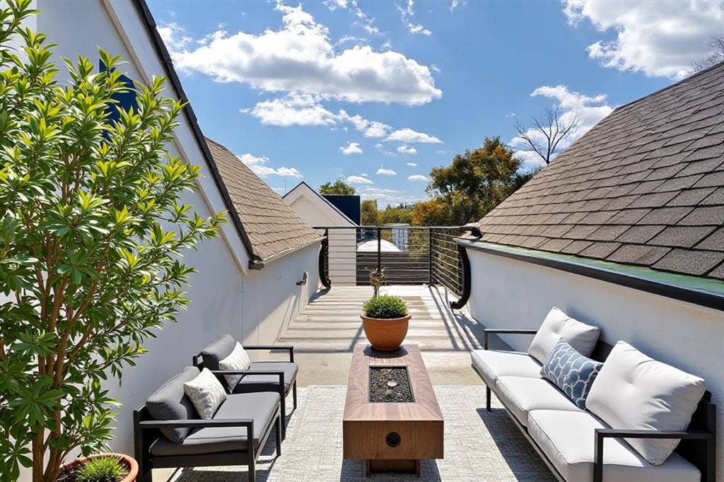 4811 Denton Drive, #201, Dallas, TX 75219 Rooftop deck featuring a horizontal slat railing, wood-finish fire pit table, and a neutral-toned hardscaping