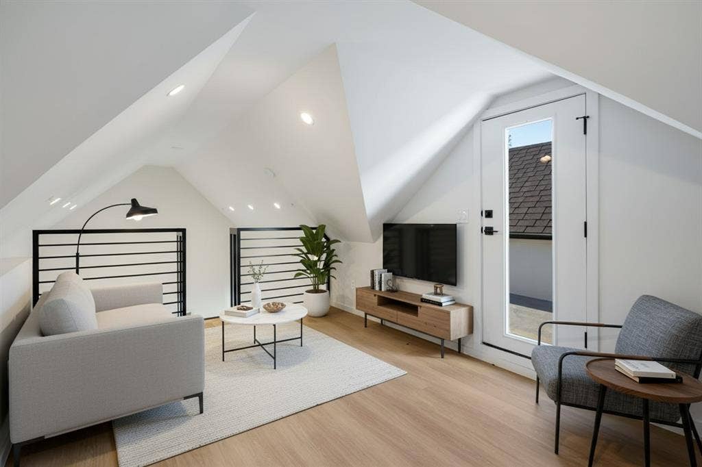 4811 Denton Drive, #201, Dallas, TX 75219 Sloped ceilings with recessed lighting, wood-finish flooring, a full-light door, and black horizontal railings