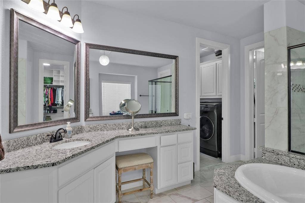 Separate vanities an access to laundry room.