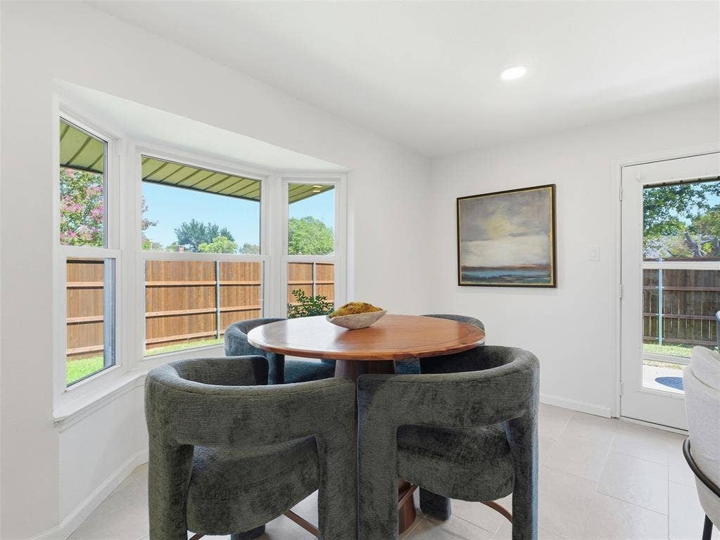 Recessed lighting, bay window, white walls, light-toned flooring, and a glass-paneled exterior door