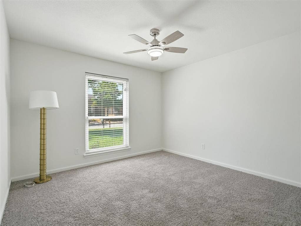 Wall-to-wall carpeting with a neutral finish, a window with horizontal blinds, and a ceiling fan with integrated lighting