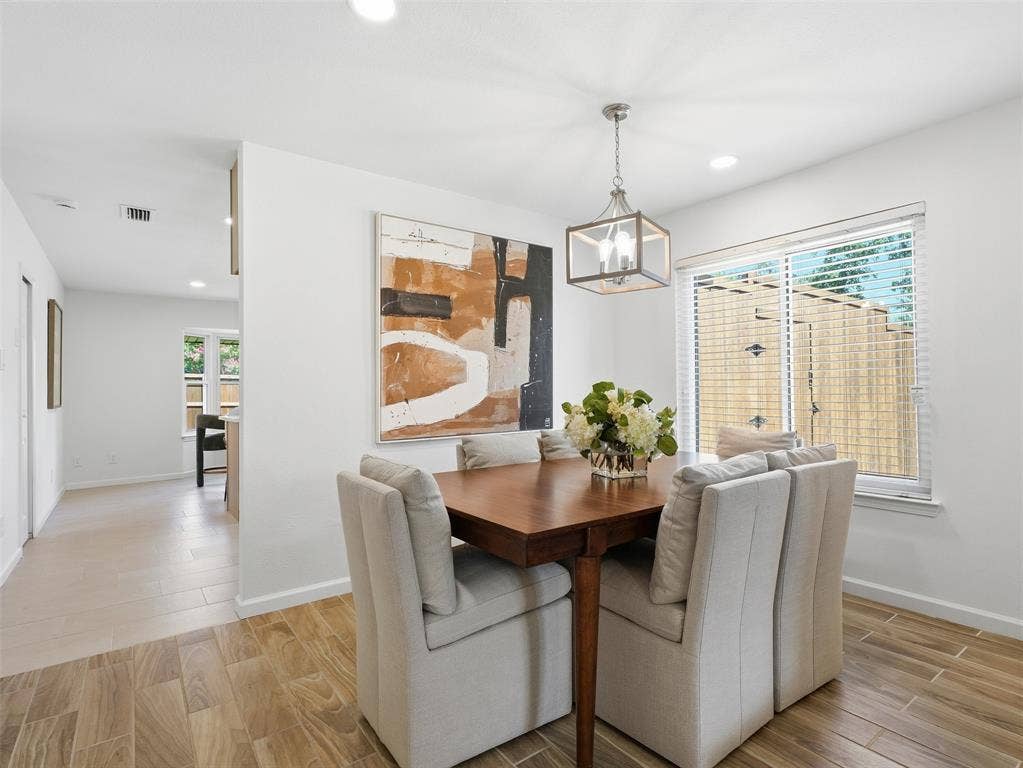 Wood-finish flooring, recessed lighting, and a contemporary chandelier