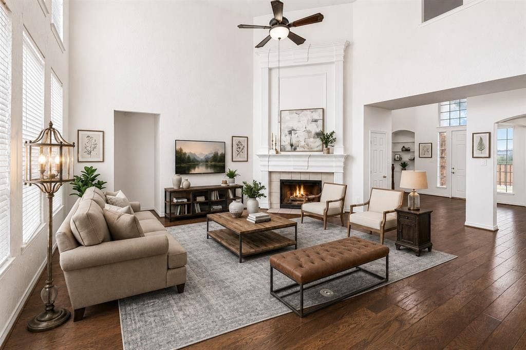 8121 Skyridge Drive, Plano, TX 75025 The open-concept family room showcases an impressive fireplace with architectural overmantel and expansive two-story ceilings. *Virtually Staged*