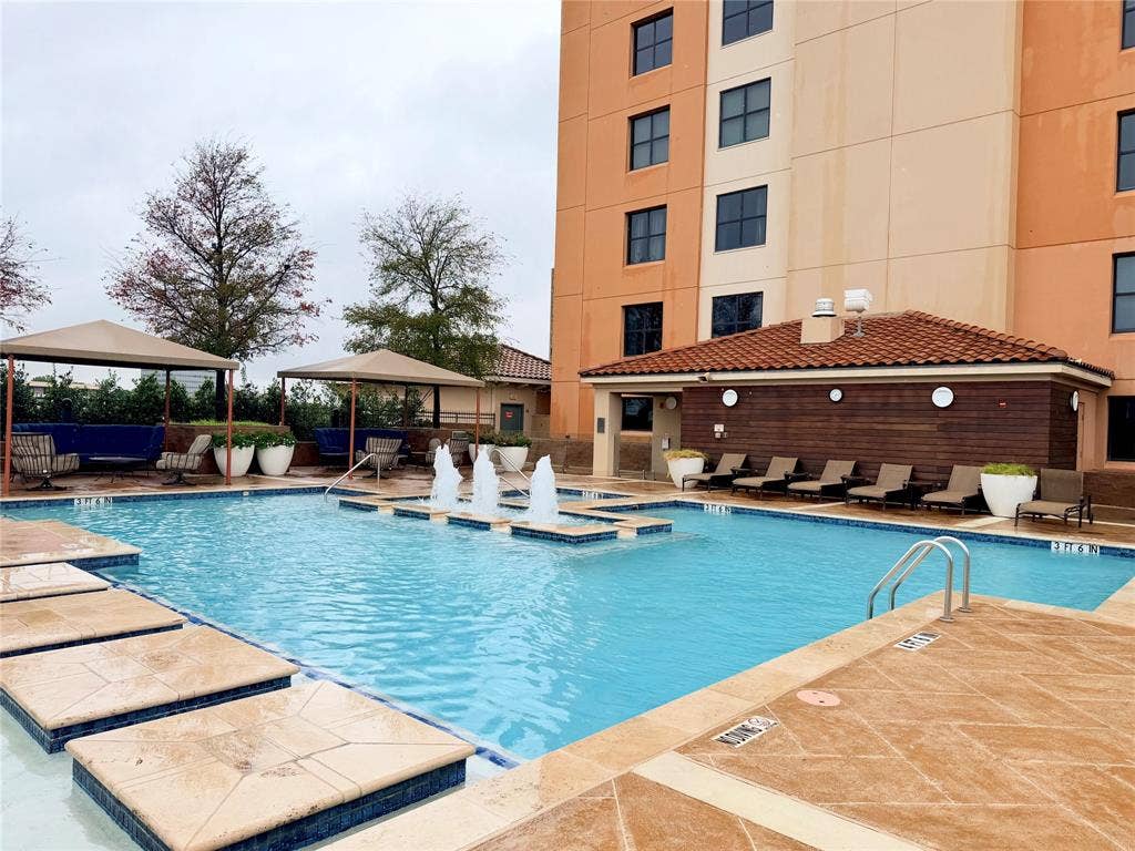330 Las Colinas Boulevard E, #1006, Irving, TX 75039 Outdoor swimming pool featuring water fountains, multiple shaded cabanas, and sun loungers