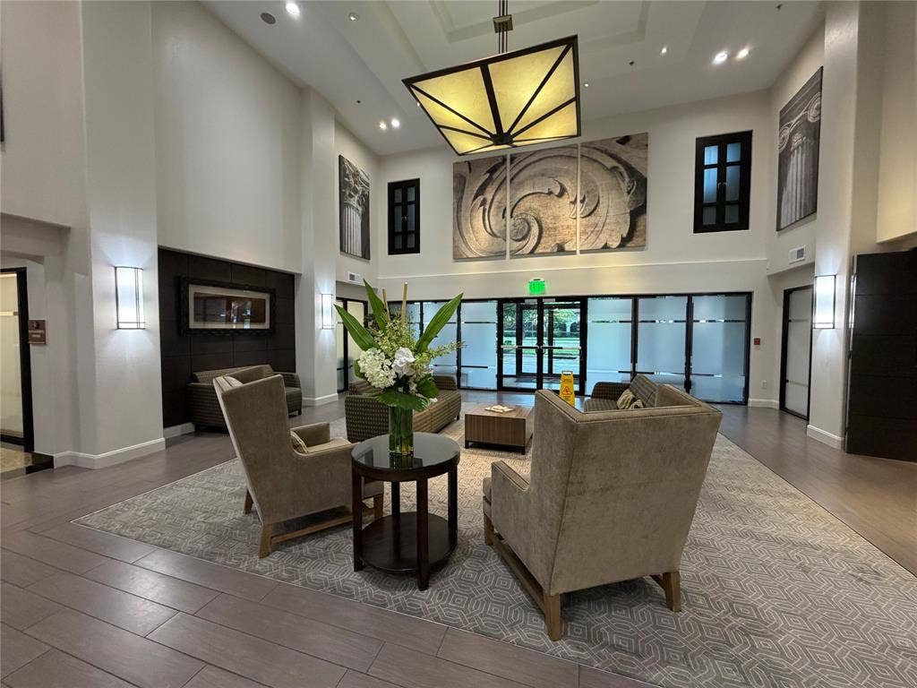 330 Las Colinas Boulevard E, #1006, Irving, TX 75039 Double-height ceiling, large decorative light fixture, wall-mounted sconces, transom windows, and wood-finish flooring