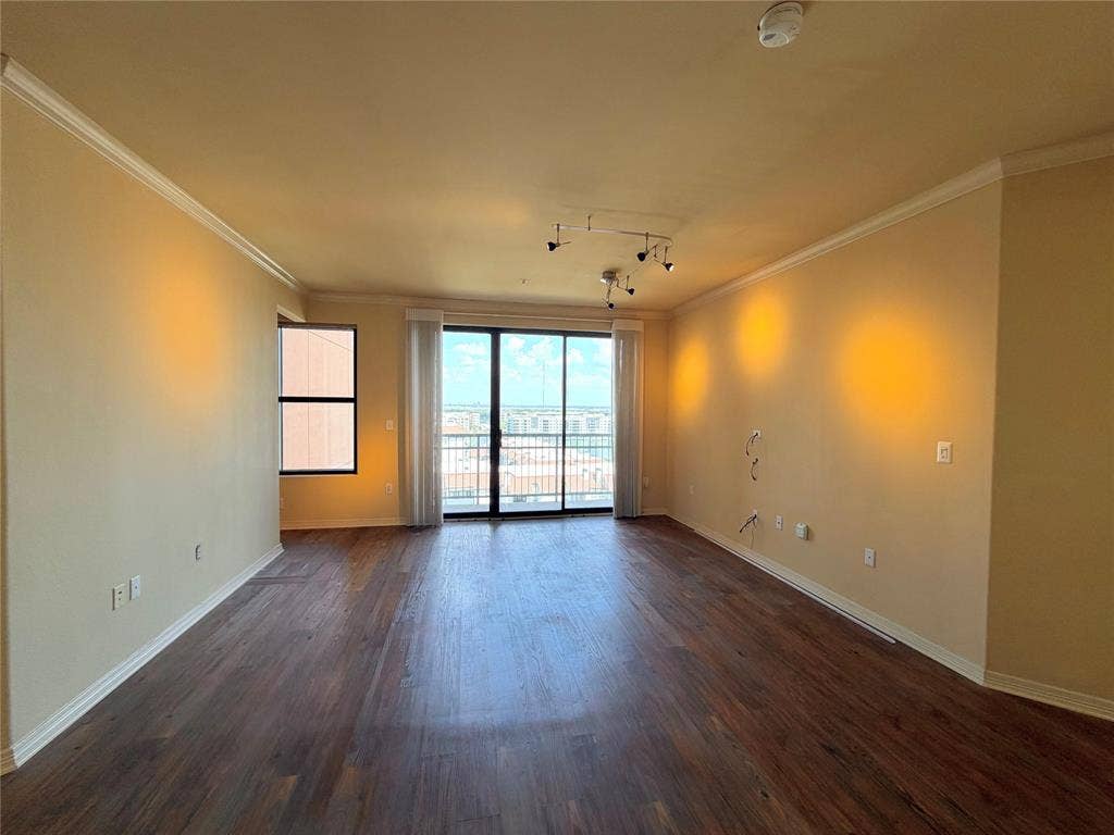 330 Las Colinas Boulevard E, #1006, Irving, TX 75039 Wood-finish flooring, crown molding, track lighting, and sliding glass doors with balcony access
